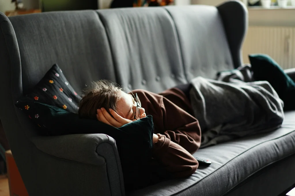 Image of person lying on grey couch