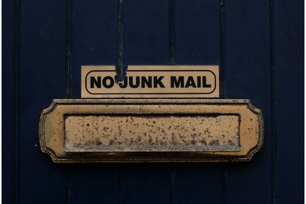 Image of a blue wall with a mailbox attached and the words "no junk mail" above
