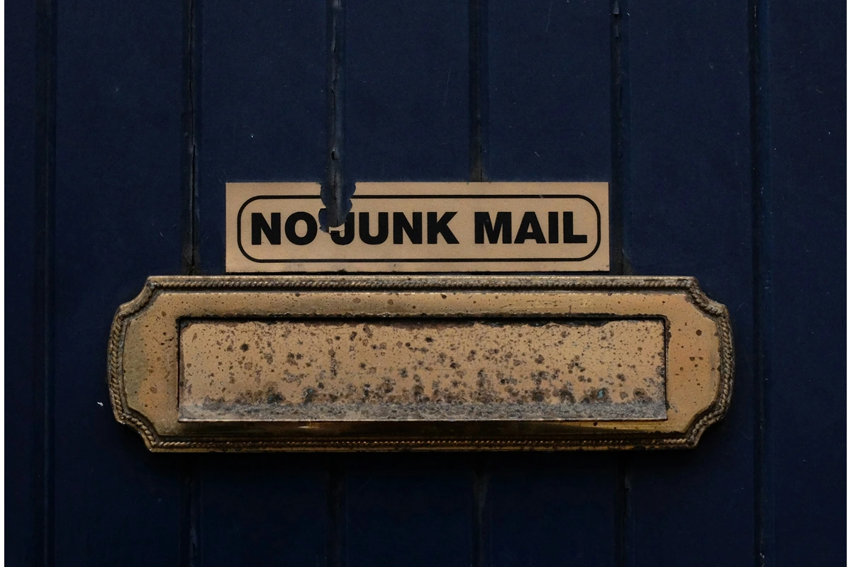 Image of a blue wall with a mailbox attached and the words "no junk mail" above
