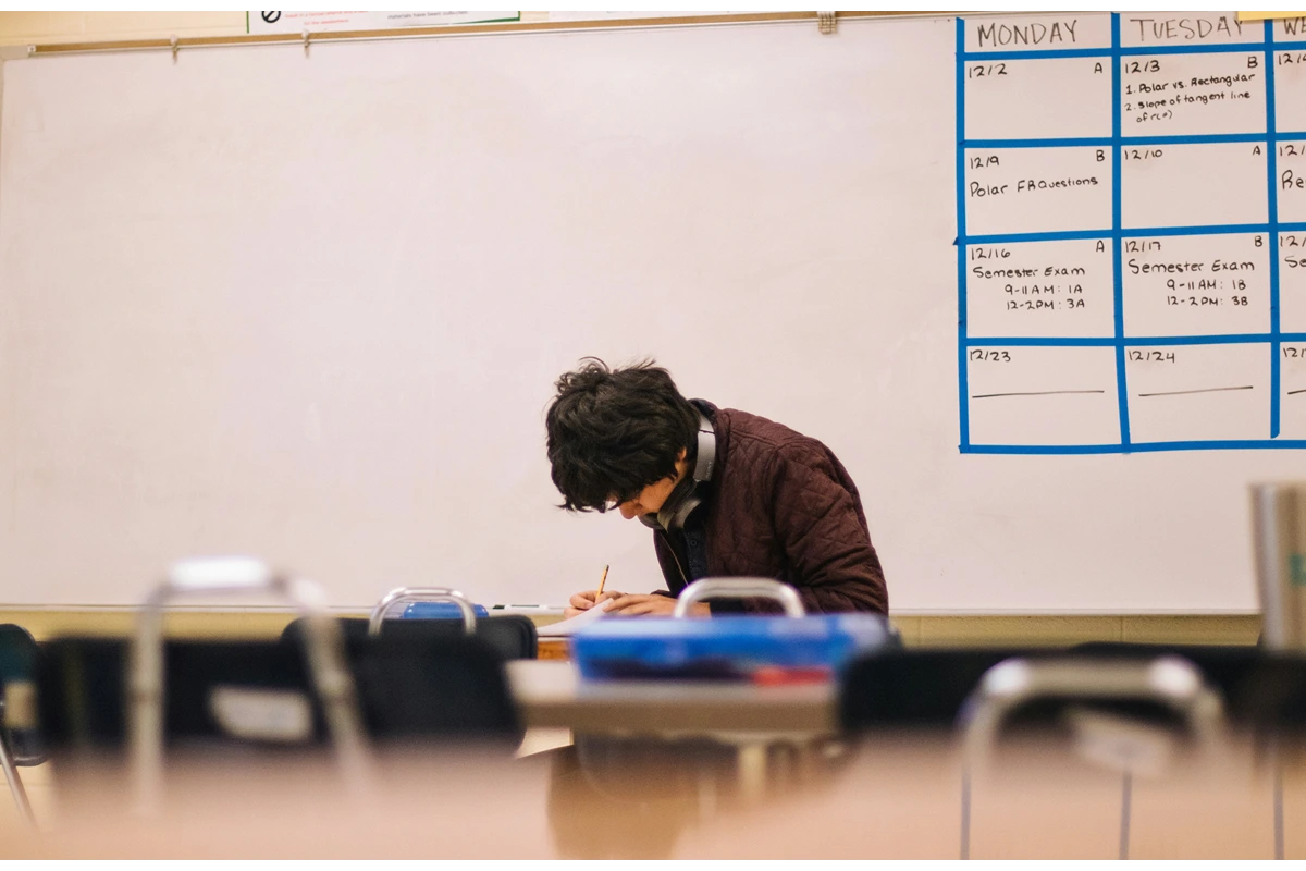image of person in classroom looking down at their work
