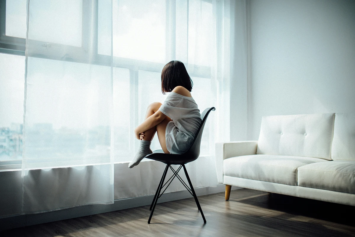 image of a person sitting on a chair looking at a window