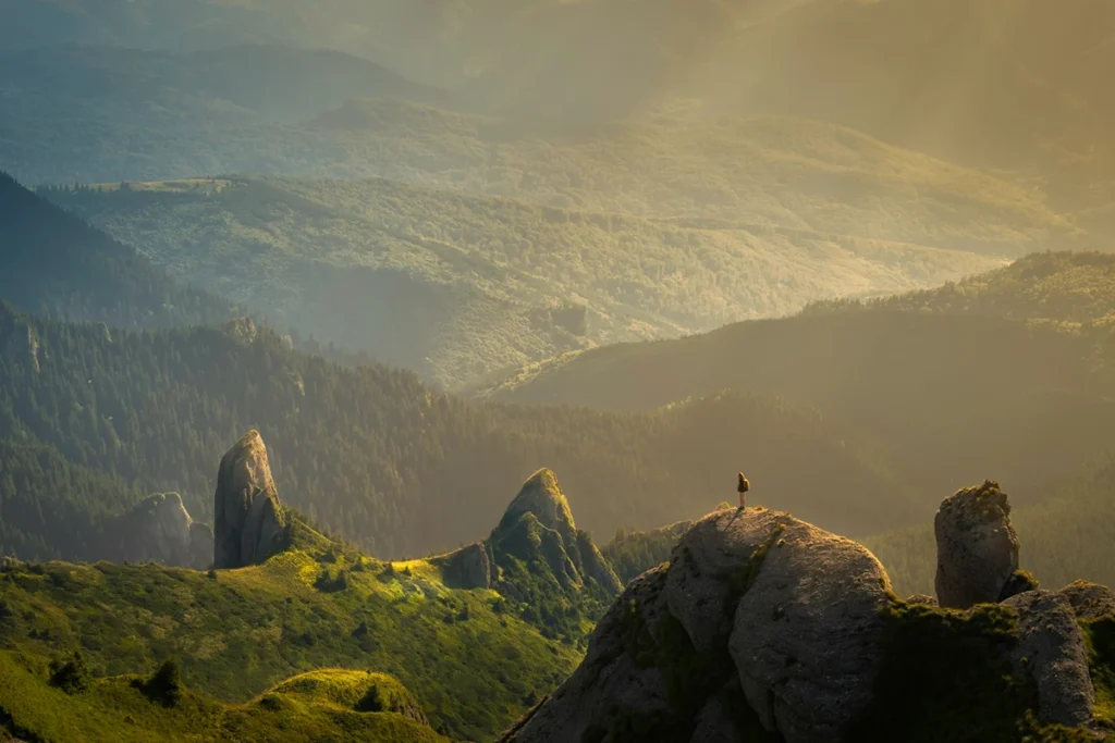 image of grassy mountains with a person standing in the distance