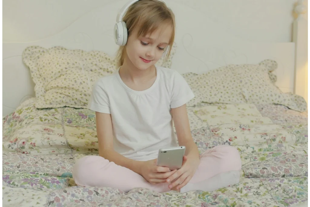 image of child on phone in their bed