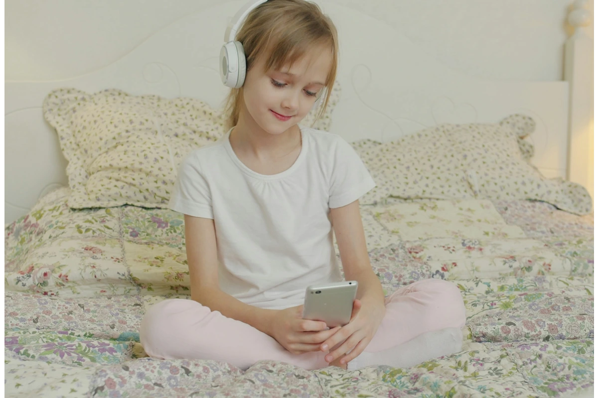 image of child on phone in their bed