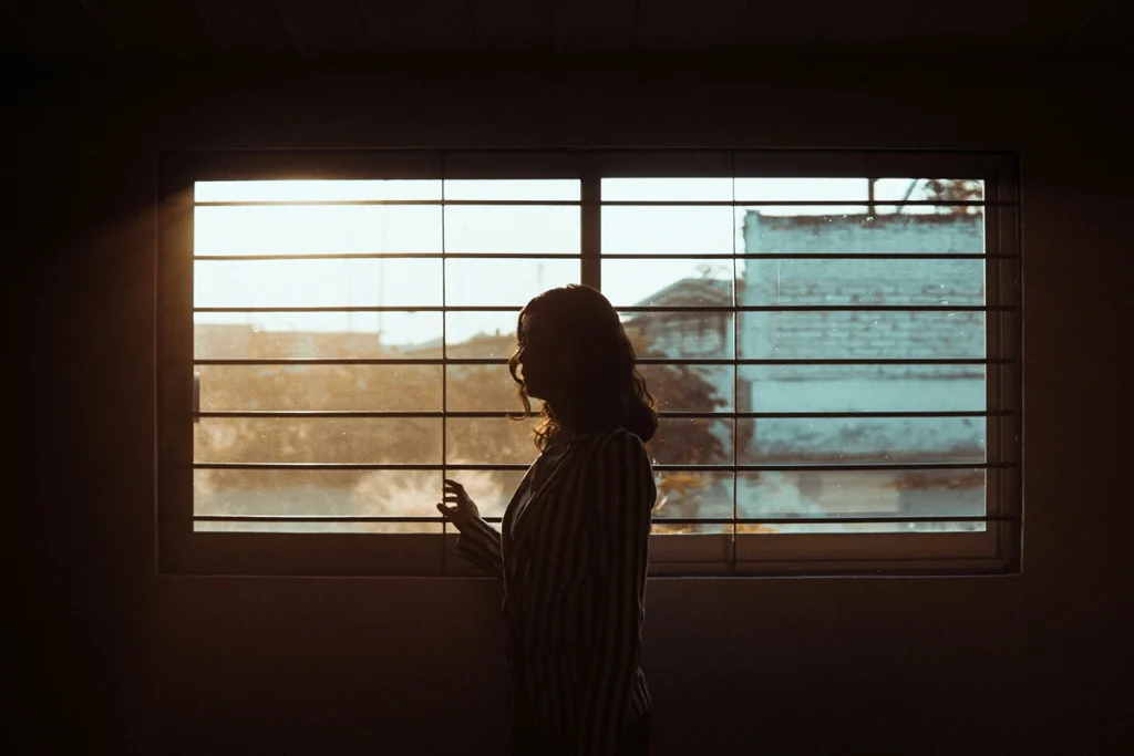Image of person in front of a window thinking
