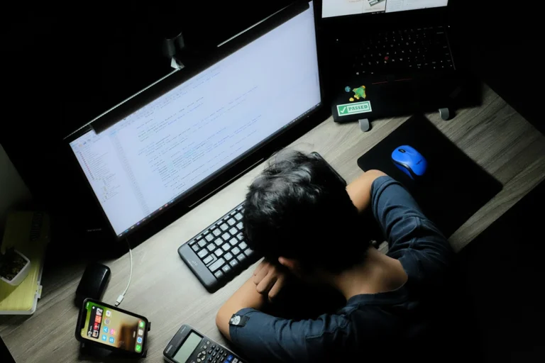 Image of person at their computer with their head on their arms