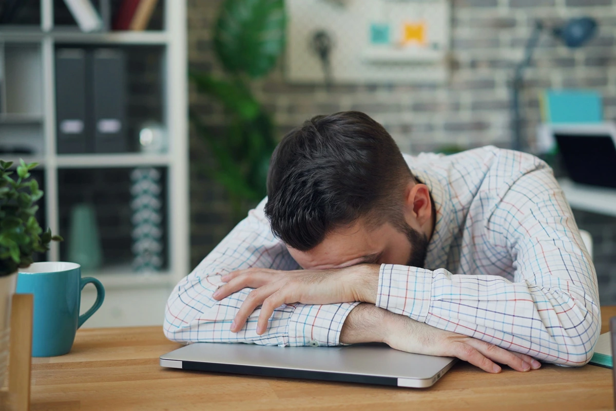 Image of person with their head on their desk