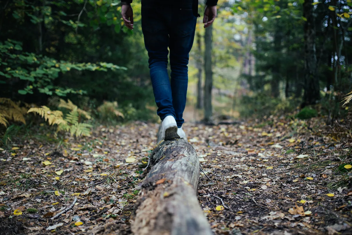 Image of person balancing on a log