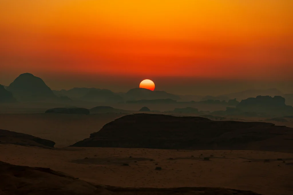 Image of sun setting above the mountains