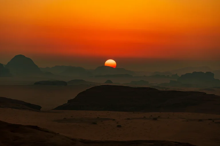 Image of sun setting above the mountains