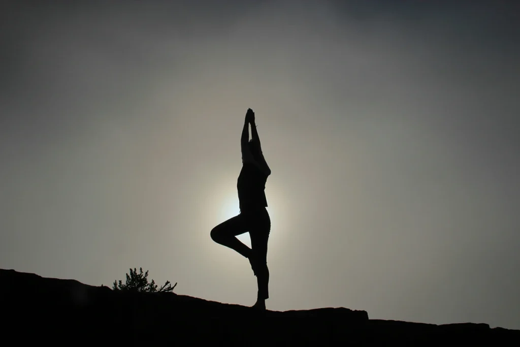 Image of person doing yoga in front of sun