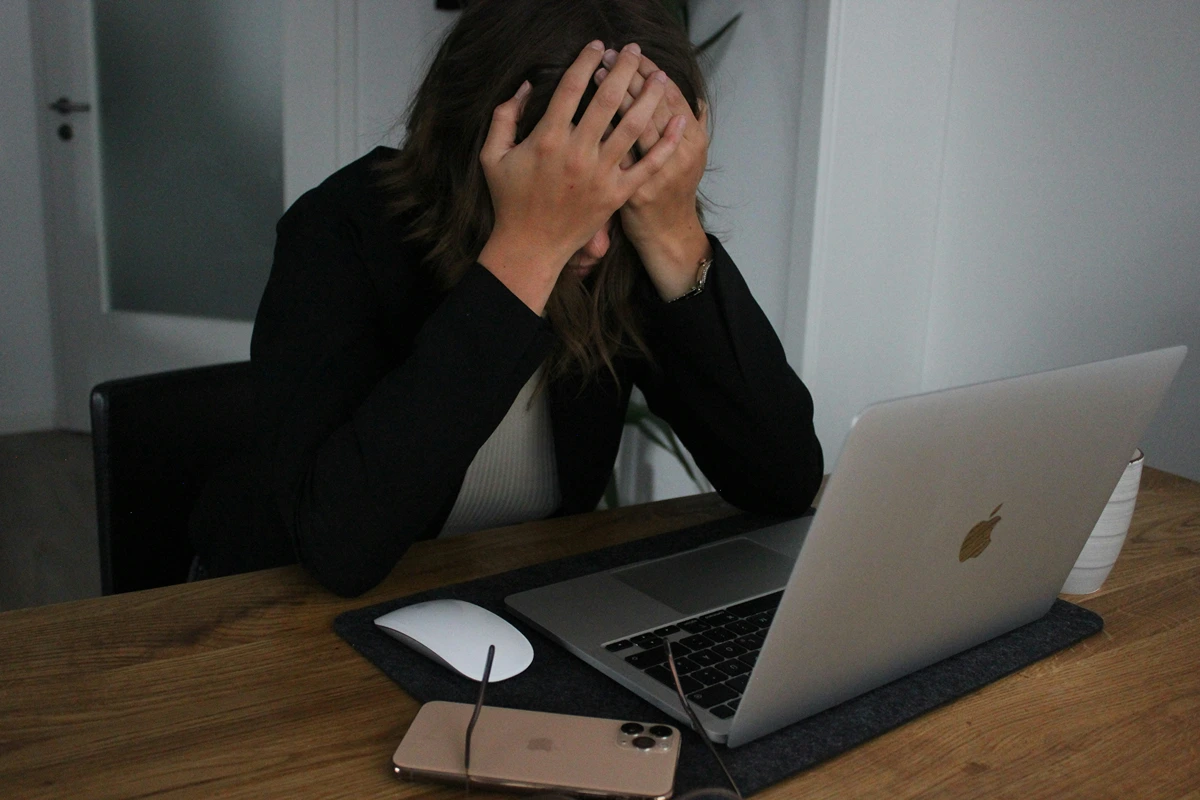 Image of person stressed with their head in their hands