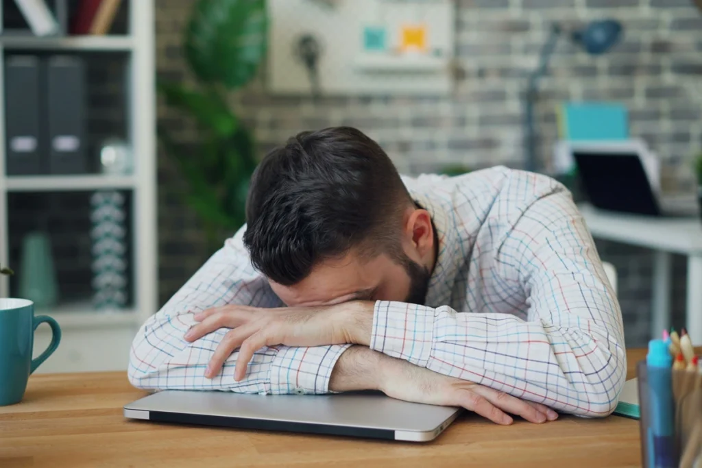 Person with their head on their laptop brain overwhelmed
